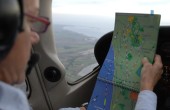 A pilot examines a map while flying