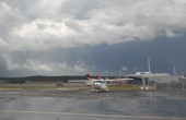 An aeroplane is parked on the apron of an airport on a cloudy day