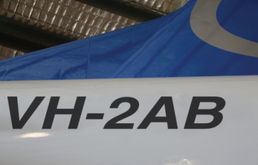 A photo of the tail of an aircraft, with the registration number VH-2AB