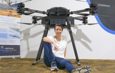 Nicola McPhail, the first remote pilot to pass the BVLOS exam, sitting in front of a large UAV