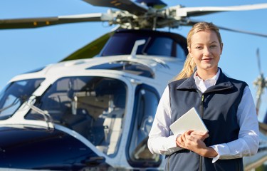 A female pilot standing proudly in from of a heliptor