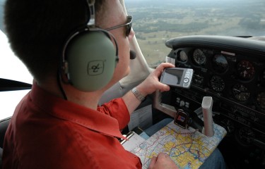 A pilot navigates with his electronic flight bag and a map