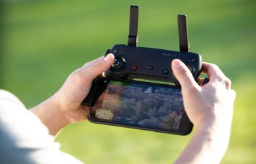 A person's hands holding an RPA remote