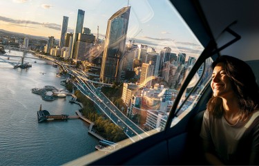 A woman riding in an AAM flying over the Brisbane CBD