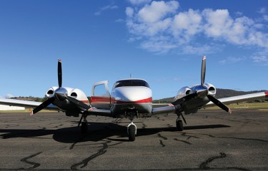 An aeroplane with its door open sitting on the apron of an airport