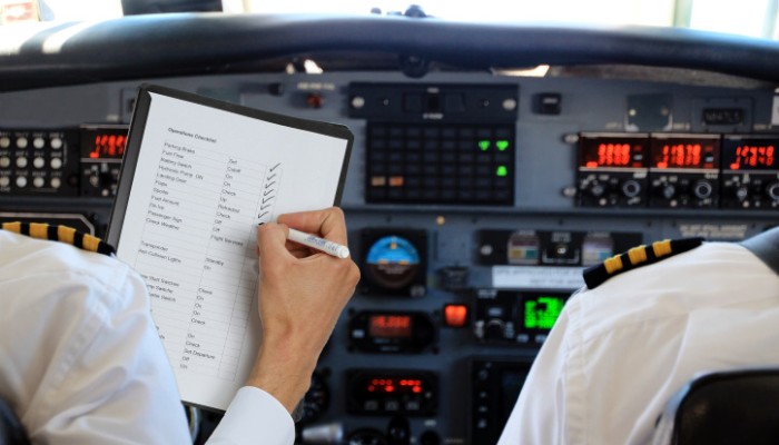 A pilot ticking off a checklist