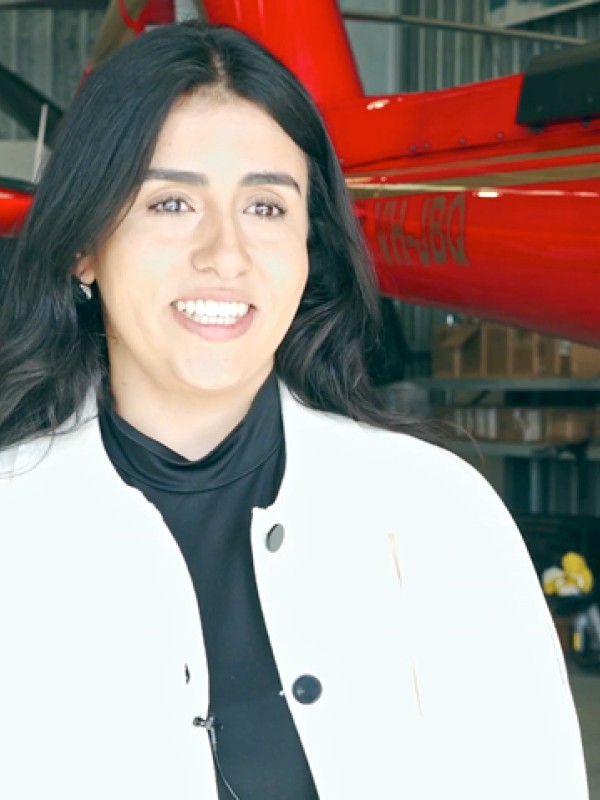 An industry speaker is interviewed in front of two helicopters