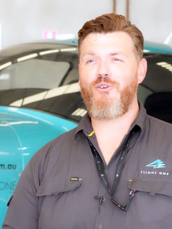 An aviation expert is interviewed in front of an aeroplane