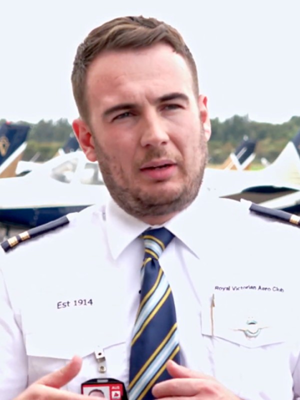An aviation expert is interviewed on an airport apron, with aeroplanes parked behind him